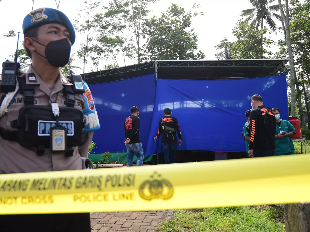 Polisi berjaga di lokasi ekshumas jenazah korban Tragedi Kanjuruhan di Tempat Pemakaman Umum (TPU) Desa Sukolilo, Kecamatan Wajak, Malang, Jawa Timur, Sabtu (5/11/2022). (ANTARA/Purnomo)