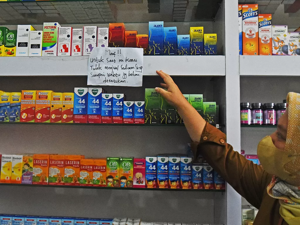 Petugas menunjukkan famplet pemberitahuan penghentian penjualan obat sirup di sebuah apotek di Cipocok, Kota Serang, Banten, Selasa (25/10/2022). (ANTARA/Asep Fathulrahman)