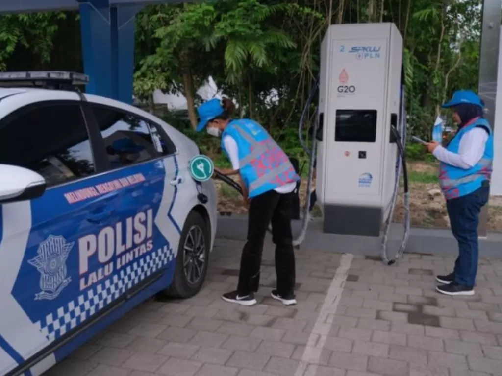 Petugas PLN sedang melakukan pengisian ulang daya baterai mobil listrik milik polisi di Sentral Parkir ITDC Nusa Dua, Badung, Bali. (ANTARA/HO-Humas PLN Bali)