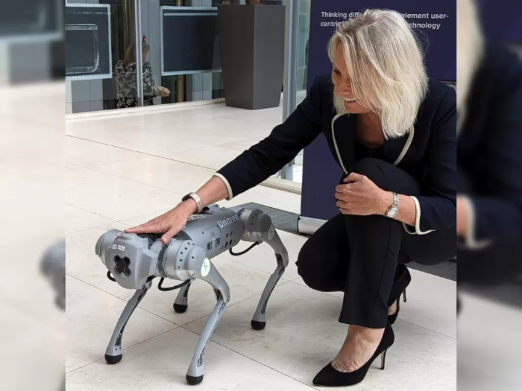 Kementerian Kehakiman Jo Farrar saat berfoto dengan robot anjing dalam pertemuan inovasi teknologi. (Twitter/Jo Farr)