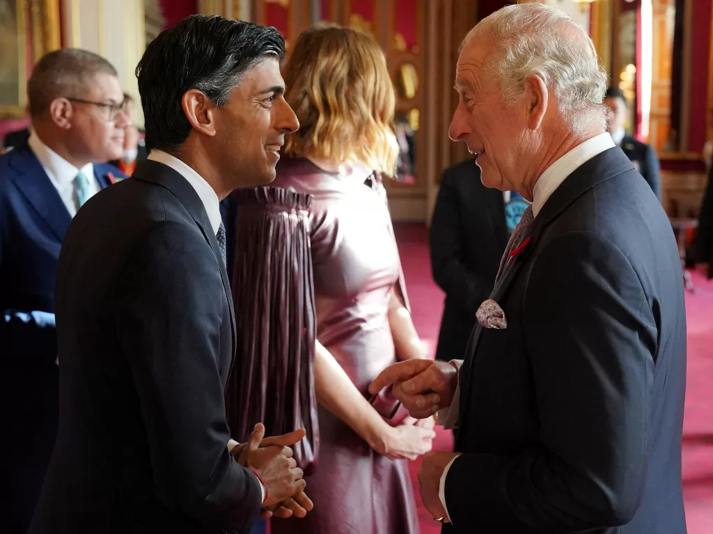 Raja Charles III berbicara dengan Perdana Menteri Rishi Sunak, saat resepsi di Istana Buckingham, London, menjelang KTT Cop27. 4 November 2022 (REUTERS/Jonathan Brady/Pool)