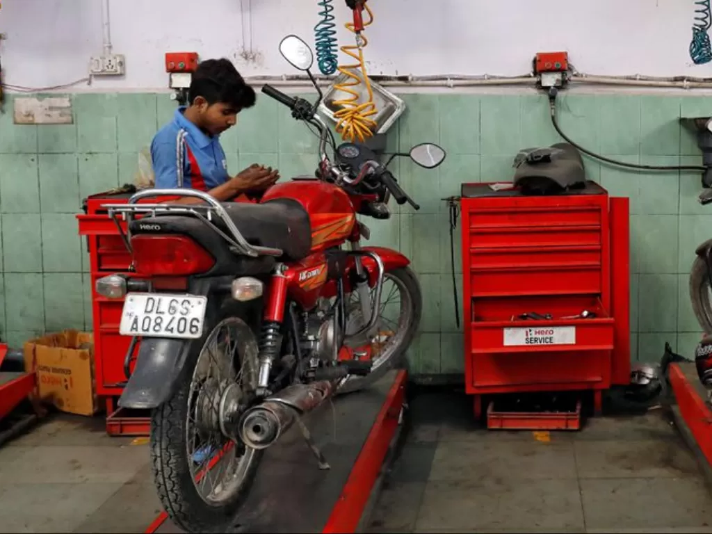 Mekanik memperbaiki sepeda motor. (REUTERS/Saumya Khandelwal)