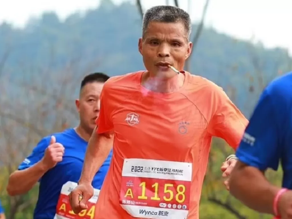 Seorang atlet maraton asal China berusia 50 tahun mengikuti lomba sambil merekok. (Weibo)