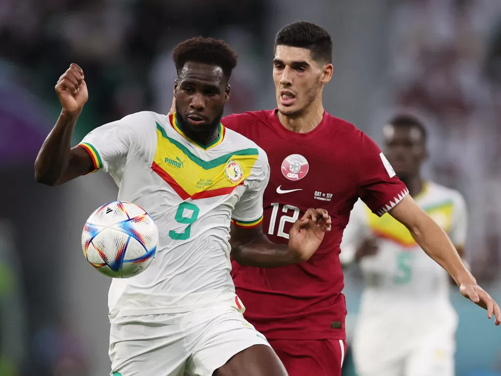 Pemain Timnas Senegal Boulaye Dia saat bertanding dengan pemain Qatar, Karim Boudiaf. (REUTERS/Amr Abdallah Dalsh)