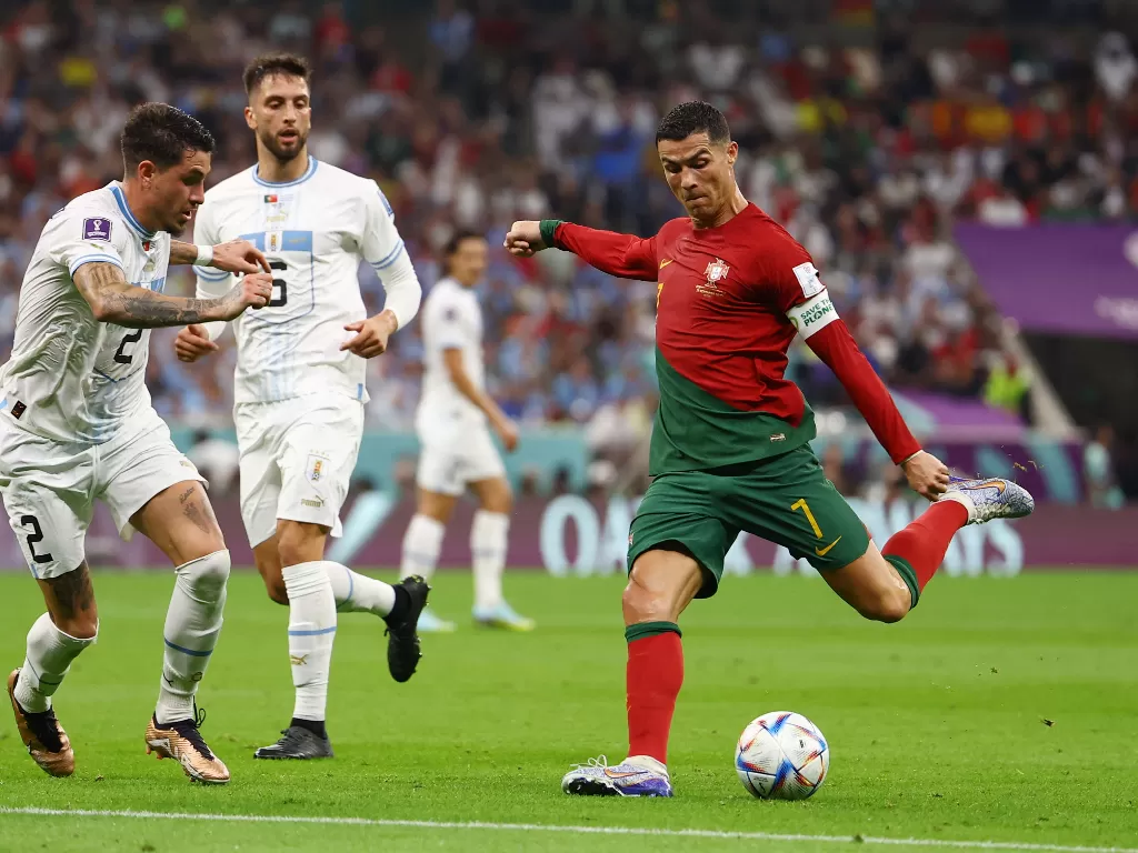 Bintang Portugal Cristiano Ronaldo coba melepaskan tembakan dalam pengawalan pemain Uruguay. (REUTERS/Kai Pfaffenbach)