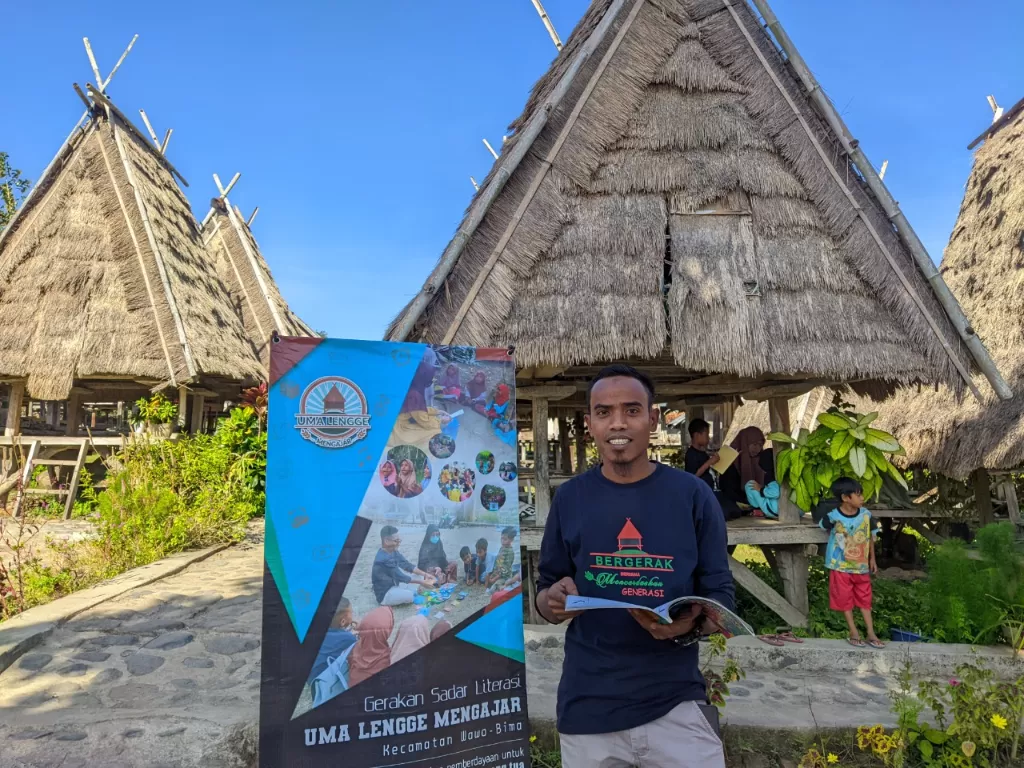 Ahmad, pegiat pendidikan di Kecamatan Wawo, Kab. Bima, Nusa Tenggara Barat, mengajak anak-anak membaca buku di Uma Lengge Mengajar (dok. Kemdikbud)