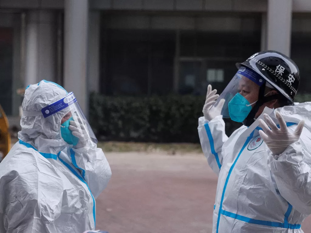 Ilustrasi - Pekerja pencegahan pandemi dengan pakaian pelindung bersiap memasuki gedung apartemen yang dikunci saat wabah penyakit virus corona (COVID-19) berlanjut di Beijing, 2 Desember 2022. (REUTERS/Thomas Peter)