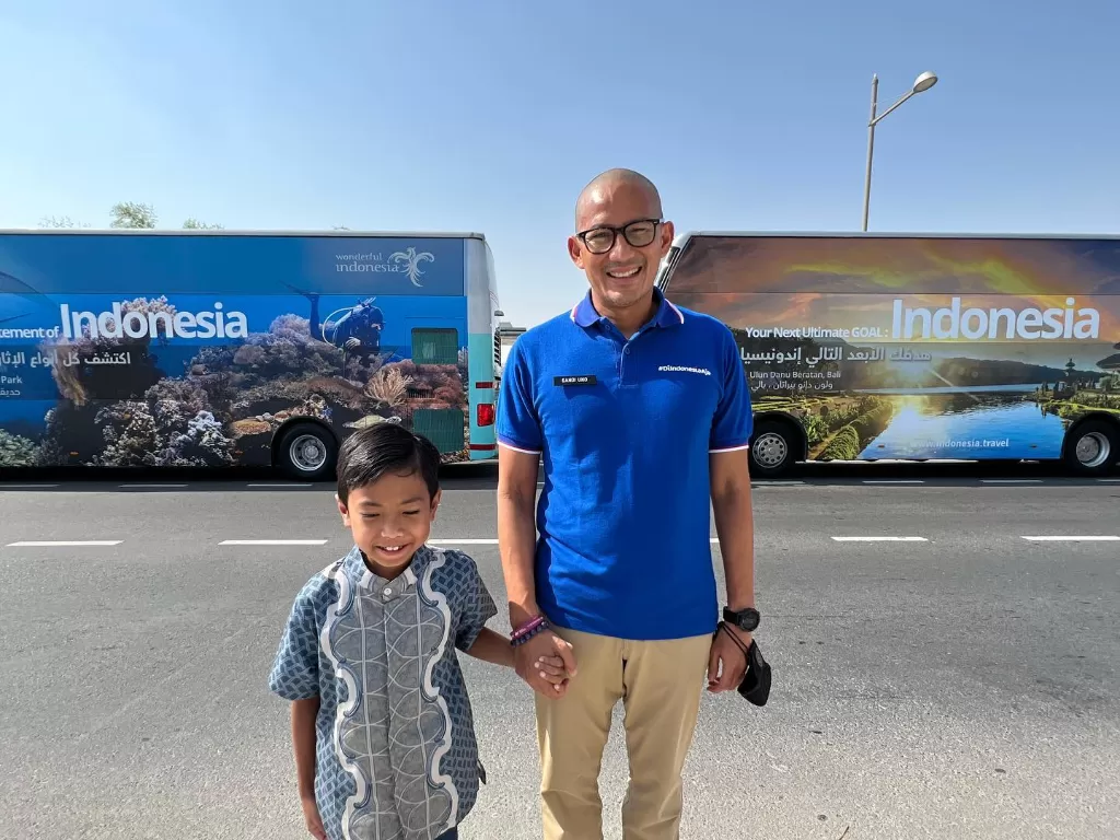 Menparekraf Sandiaga Uno berpose di depan bus dengan pemandangan tempat wisata di Indonesia. (Instagram/@sandiuno)