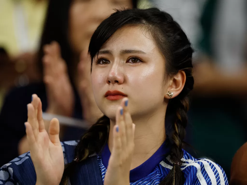 Suporter cantik timnas Jepang berlinang air mata usai Samurai Biru tersingkir dari Piala Dunia 2022. (REUTERS/John Sibley)