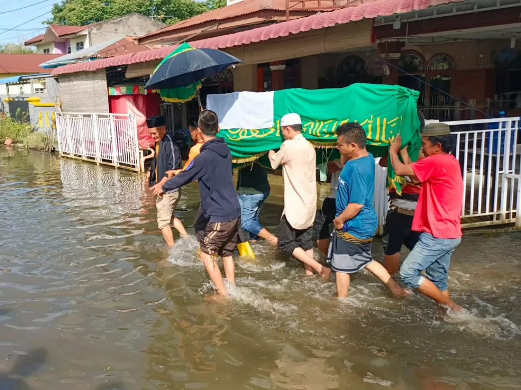 Warga gotong keranda lintasi banjir (Z Creators/Muhammad Hijrah)