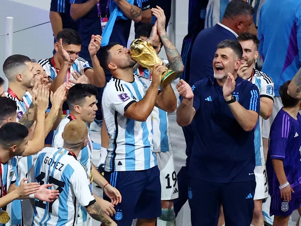 Sergio Aguero ikut mencium trofi Piala Dunia usai Argentina Juara. (REUTERS/Molly Darlington).