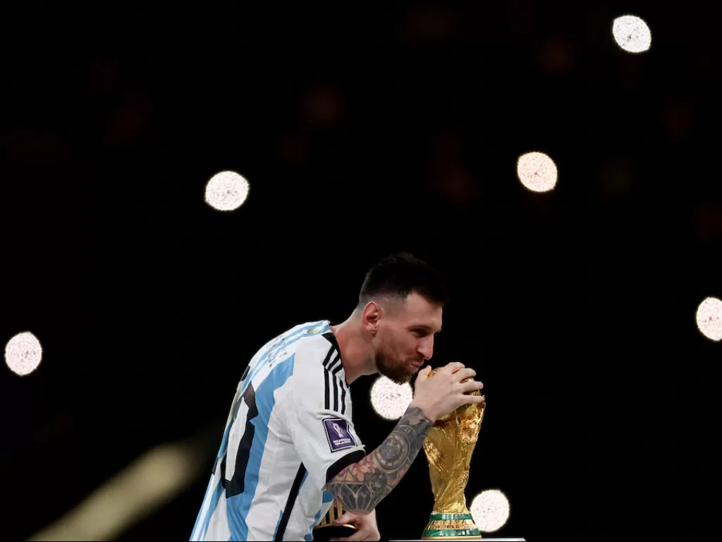 Kapten Timnas Argentina Lionel Messi mencium trofi Piala Dunia (REUTERS/Lee Smith)