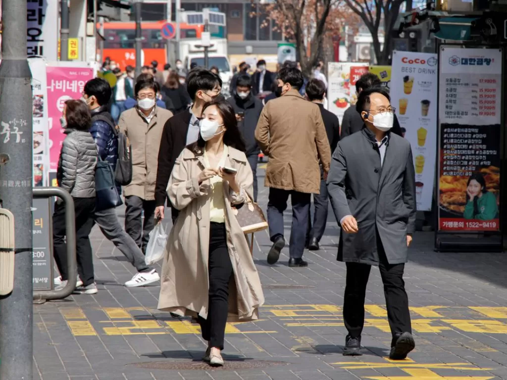 Ilustrasi - Orang-orang yang memakai masker berjalan di kawasan perbelanjaan di tengah pandemi penyakit virus corona (COVID-19) di Seoul, Korea Selatan, 16 Maret 2022. (REUTERS/Heo Ran)