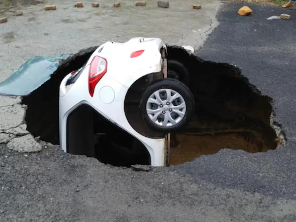 Sebuah lubang terbuka di Sektor 18 Dwarka menelan mobil yang sedang melintas di atasnya. (India Today)
