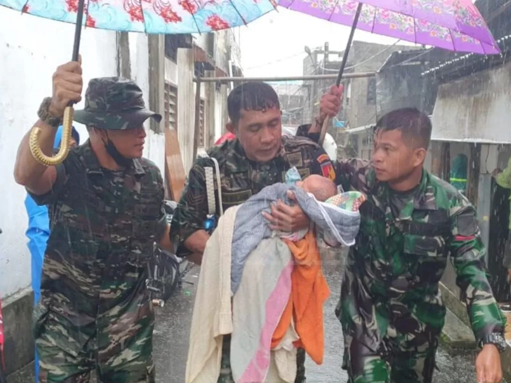 Prajurit TNI AD selamatkan bayi saat banjir besar rendam Manado. (Dok. Dispenad)