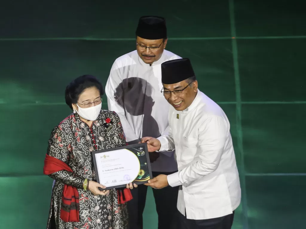 Presiden ke-5 RI Megawati Soekarnoputri (kiri) mewakili Presiden RI pertama Soekarno menerima penghargaan kategori nasional yang diberikan oleh Ketua PBNU. (ANTARA FOTO/Asprilla Dwi Adha)