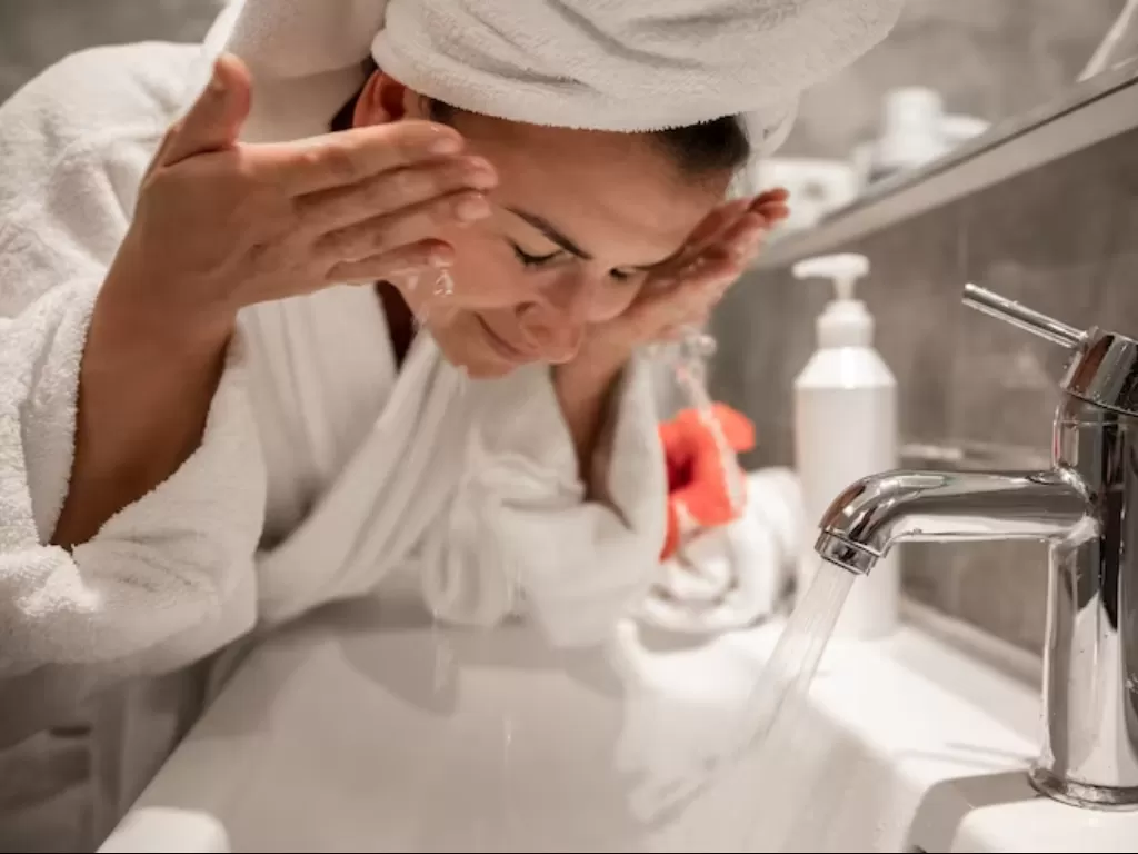 Ilustrasi wanita mencuci muka. (FREEPIK)