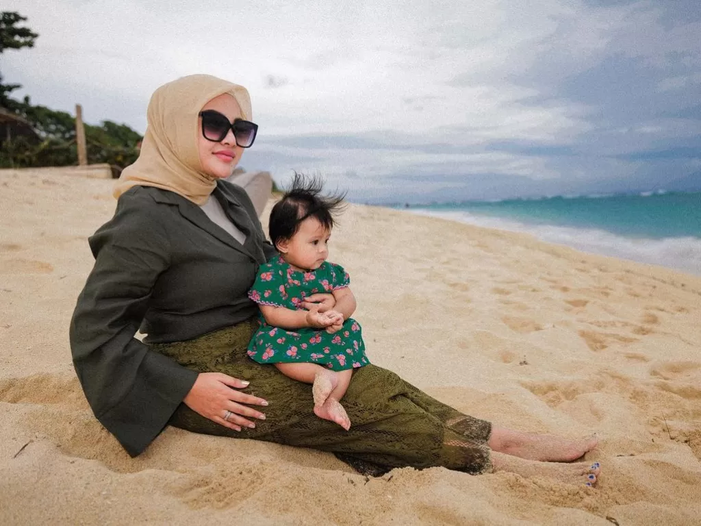 Aurel Hermansyah dan anaknya, Ameena Hanna Nur Atta, saat berada di pinggir pantai. (Instagram/aureliehermansyah)