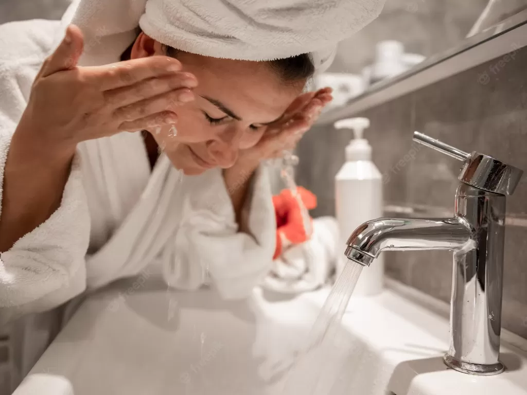 Ilustrasi wanita mencuci muka. (Freepik)