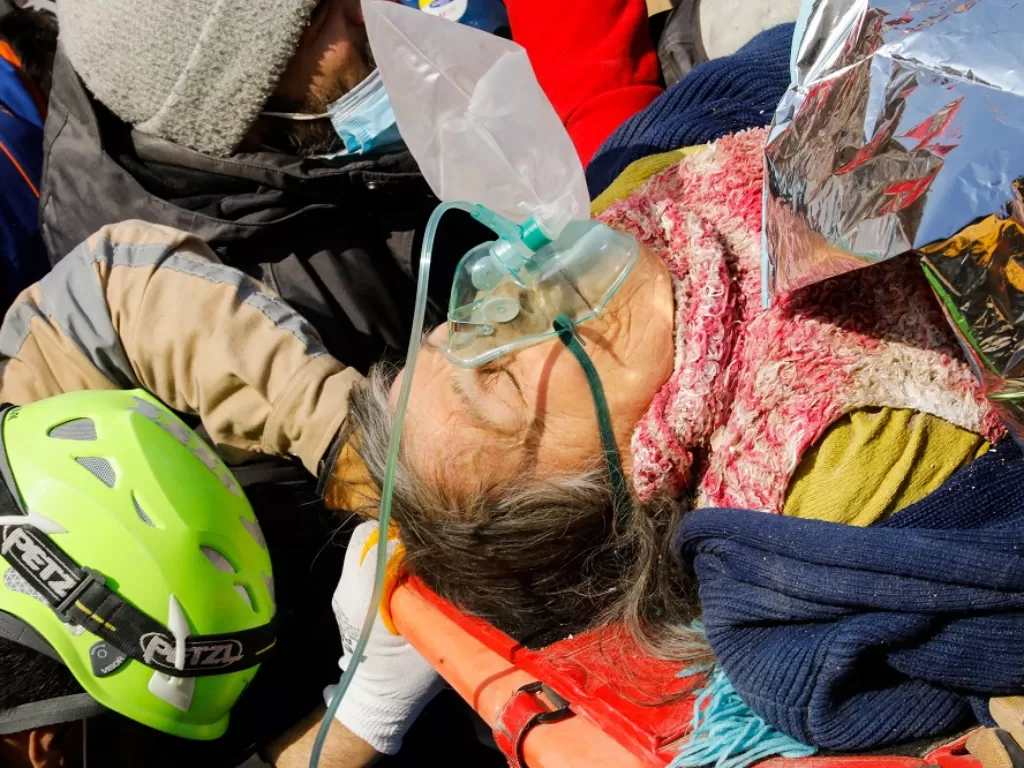 Seorang ibu diselamatkan dari reruntuhan gedung akibat gempa Turki (REUTERS/Umit Bektas)
