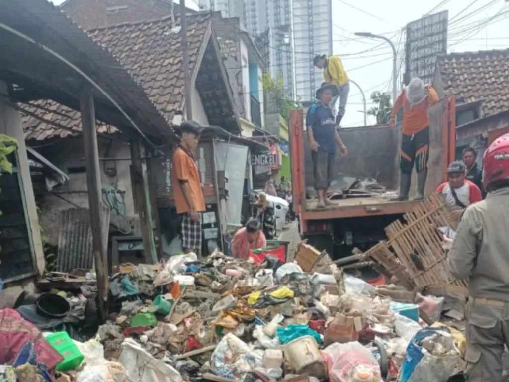 Sejumlah petugas Dinas Lingkungan Hidup (DLH) menangani tumpukan sampah di rumah salah seorang warga di Jemur Gayungan I Kota Surabaya, Jatim. (ANTARA HO-DLH Surabaya)