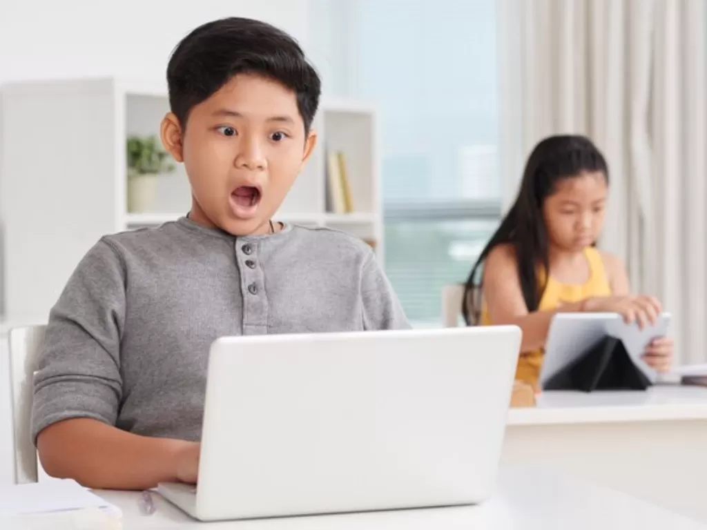 Ilustrasi seorang anak sedang menonton tayangan di laptop. (FREEPIK/pressfoto)