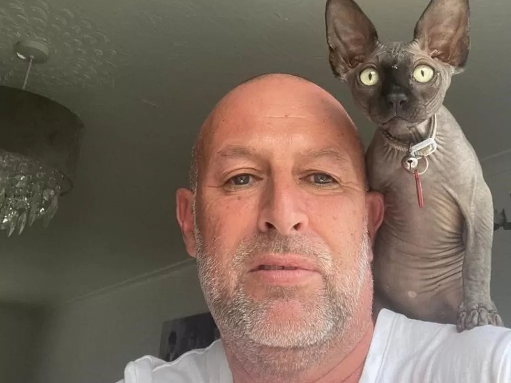 Chris Rowley bersama kucing kesayangannya. (BBC)