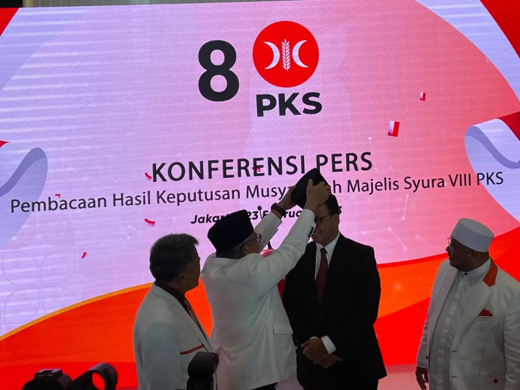 Presiden PKS Pakaikan Anies Baswedan Peci Hitam (INDOZONE/Asep Bidin Rosidin)