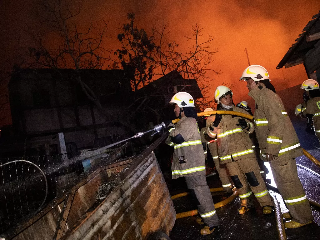 Sejumlah petugas berusaha memadamkan api yang membakar rumah warga imbas kebakaran Depo Pertamina Plumpang,kawasan Jalan Koramil, Rawa Badak Selatan, Koja, Jakarta Utara, Jumat (3/3/2023). (ANTARA/M Risyal Hidayat)