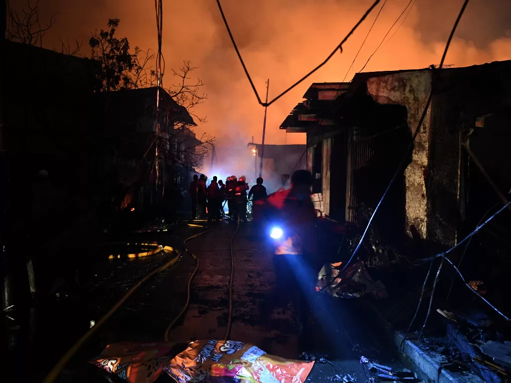 Sejumlah petugas berusaha memadamkan api yang membakar rumah warga imbas kebakaran Depo Pertamina Plumpang,kawasan Jalan Koramil, Rawa Badak Selatan, Koja, Jakarta Utara, Jumat (3/3/2023). (ANTARA/M Risyal Hidayat)