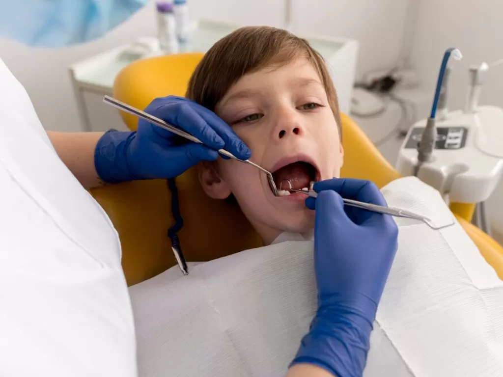 Ilustrasi anak menjalani pemeriksaan gigi berlubang (freepik)