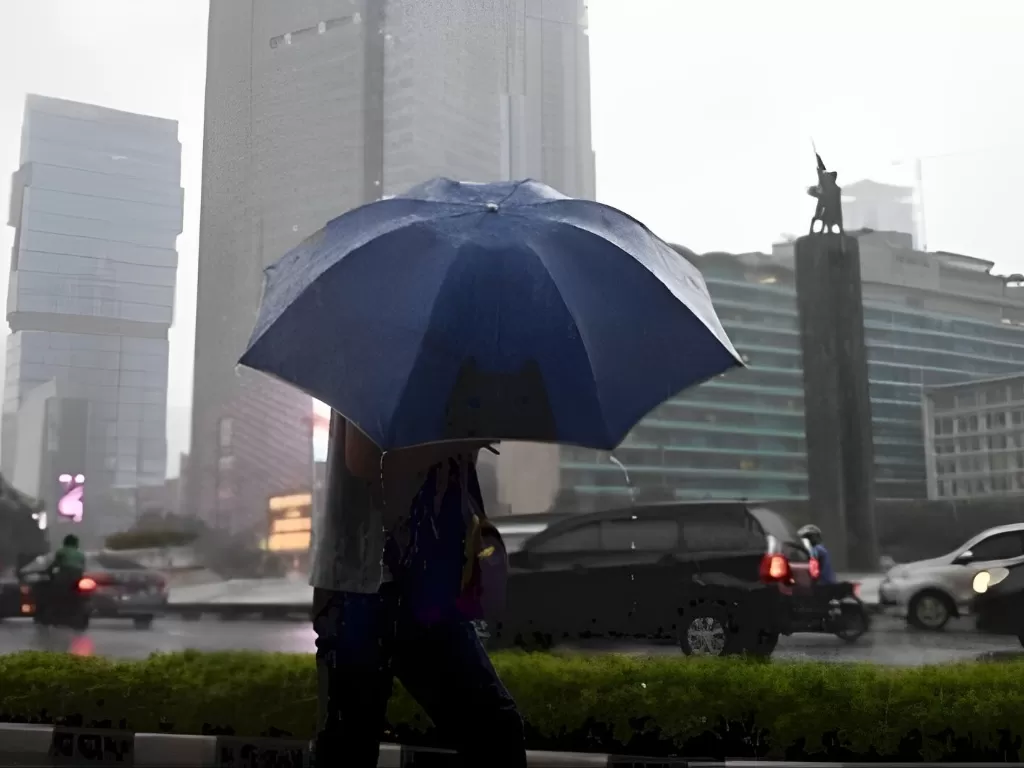Ilustrasi Warga menggunakan payung untuk menghindari hujan saat melewati kawasan Bundaran Hotel Indonesia, Jakarta. (ANTARA/HO-Akbar Nugroho Gumay) 