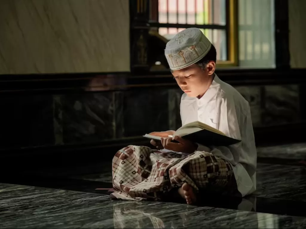 Ilustrasi anak sedang membaca Al- Qur'an. (Freepik/nongsurachai)