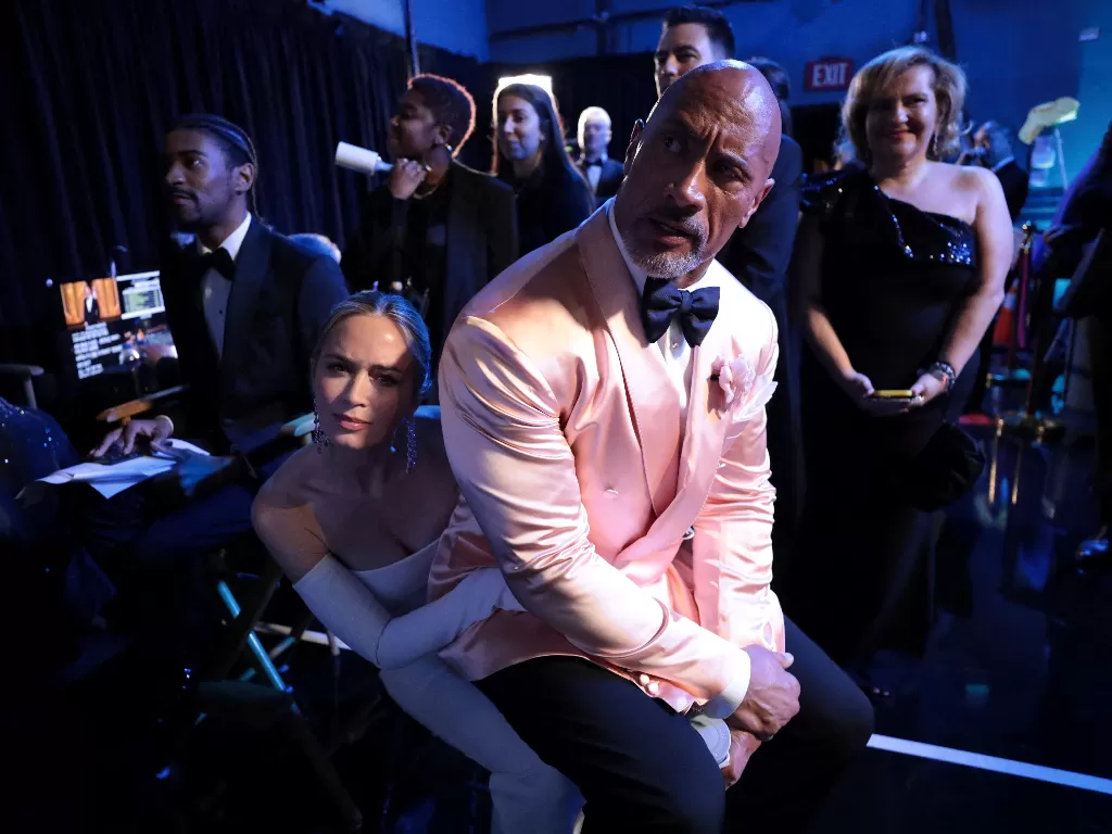 Dwayne Johnson duduk di pangkuan Emily Blunt di Academy Awards ke-95. (REUTERS/AMPAS/Al Seib)