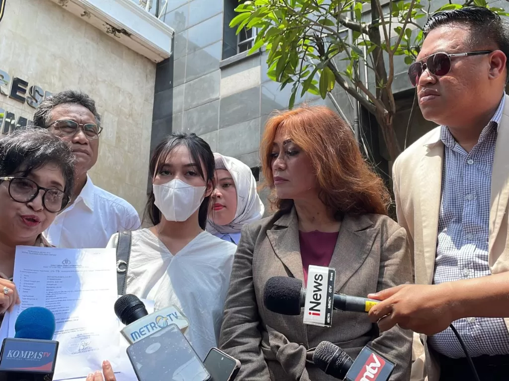 Sosok 'APA' (tengah) dan pengacaranya, Enita (tengah kanan) di Mapolda Metro Jaya, Jakarta (INDOZONE/Samsudhuha Wildansyah)