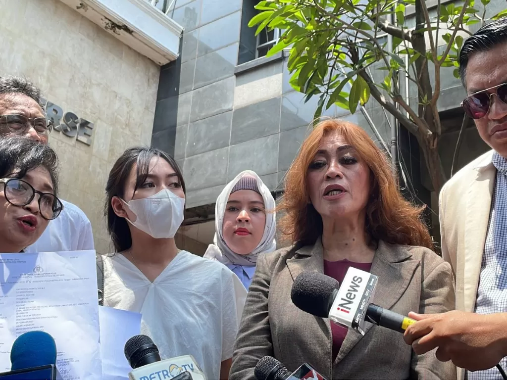 Sosok 'APA' (tengah) dan pengacaranya, Enita (tengah kanan) di Mapolda Metro Jaya, Jakarta. (INDOZONE/Samsudhuha Wildansyah)