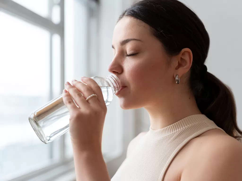 Ilustrasi wanita minum air putih. (Freepik)