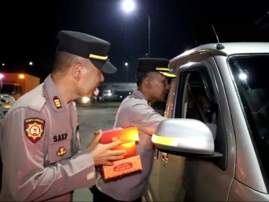 Personel Polsek Cileunyi berbagi nasi kotak bagi pengguna jalan. (Z Creator/Martin)