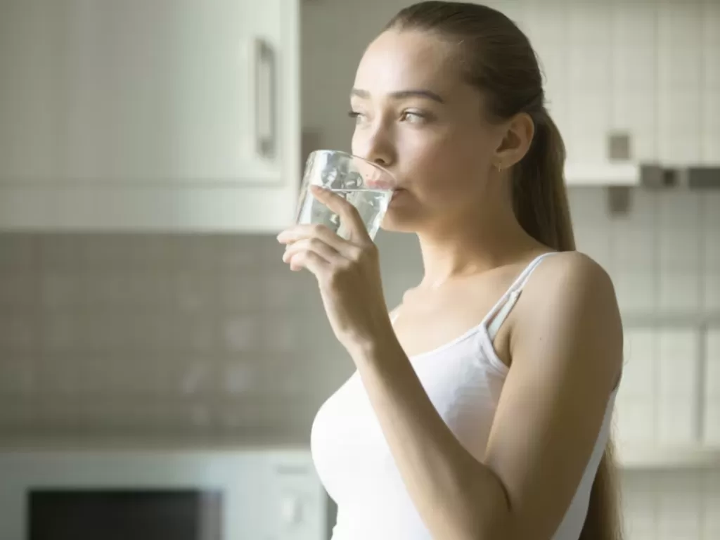 Ilustrasi wanita minum air putih. (Freepik)