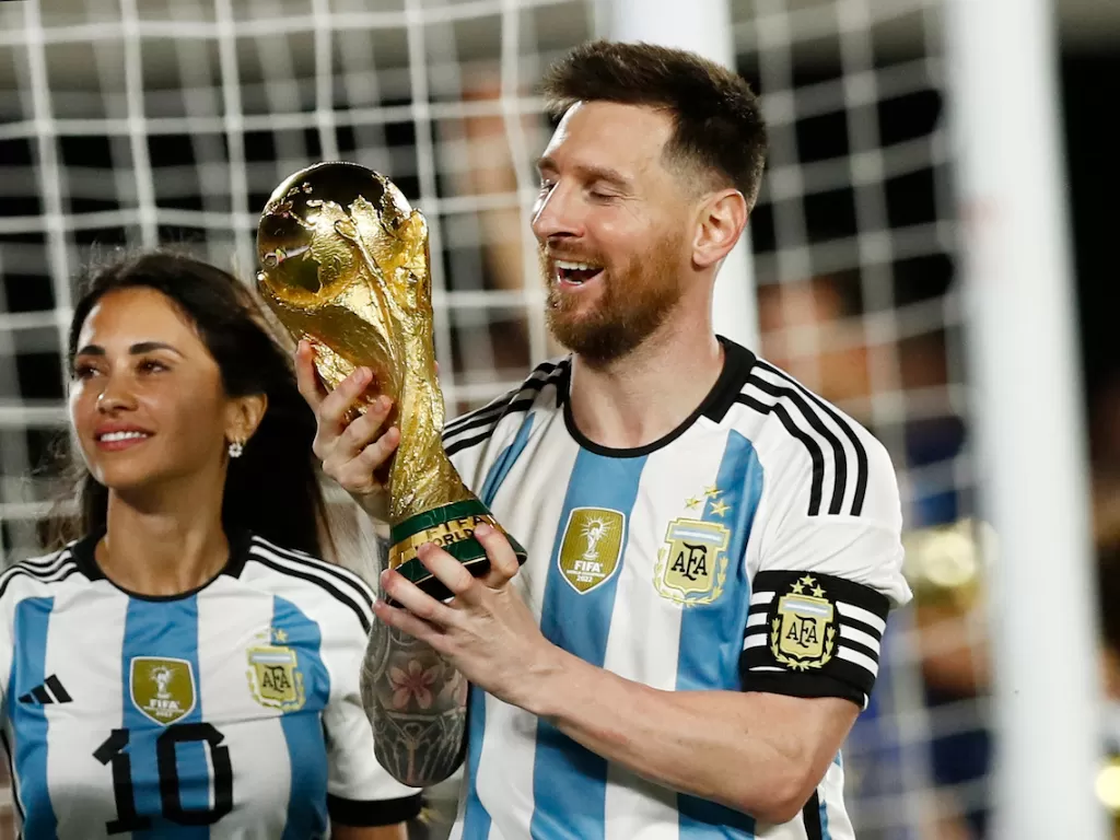 Lionel Messi memegang trofi Piala Dunia (REUTERS/Agustin Marcarian)