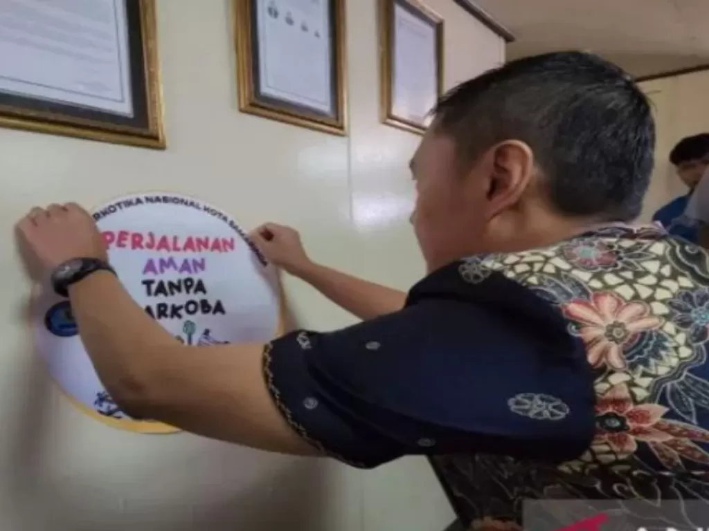 Kepala BNNK Samarinda Kombes Pol Wiwin Firta saat menempel stiker tentang bahaya narkoba di Pelabuhan Samarinda. (ANTARA/Fandi)