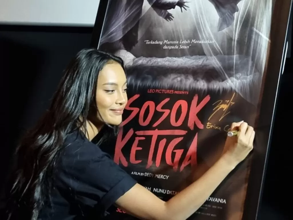 Erika Carlina menandatangani poster film Sosok Ketiga (INDOZONE/Arvi Resvanty)