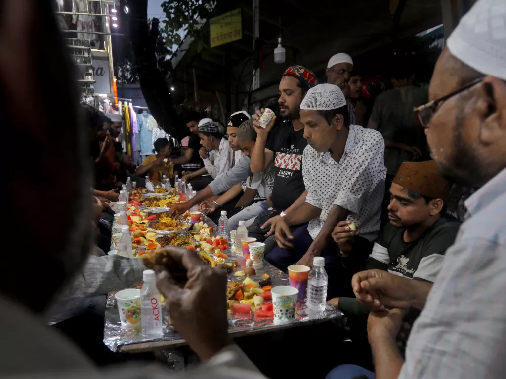 Umat muslim sedang berbuka puasa di pasar selama bulan puasa Ramadhan, di Mumbai, India, 4 April 2023. (REUTERS/Niharika Kulkarni)