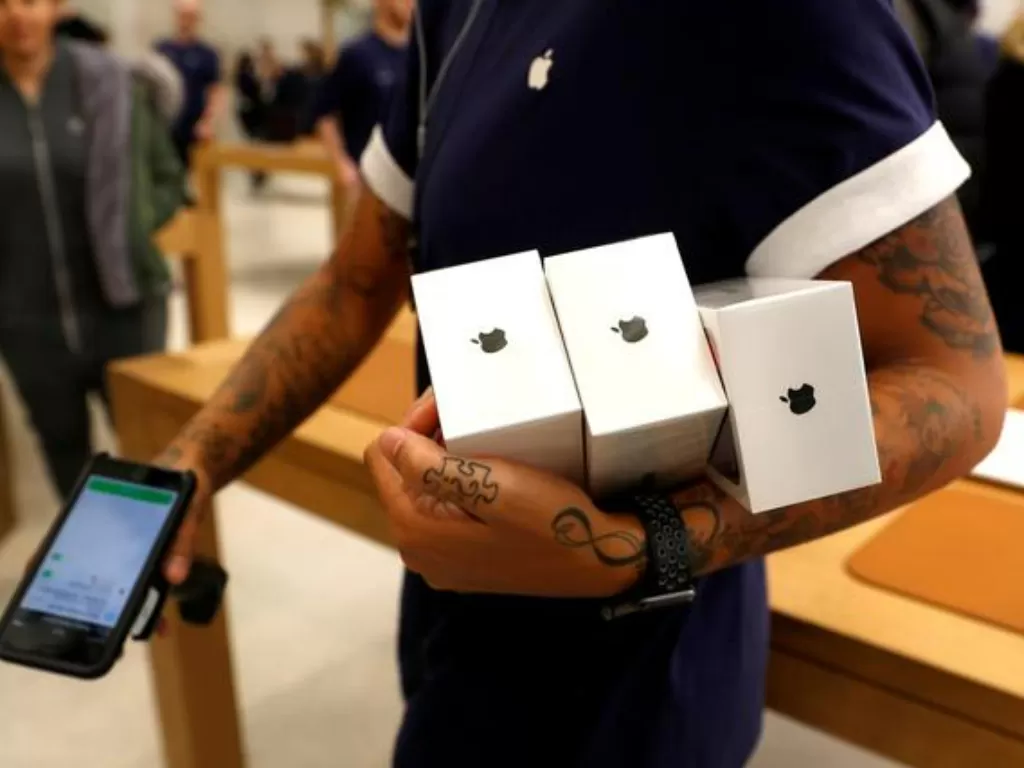 Ilustrasi petugas Apple Store sedang membawa iPhone baru untuk dijual. (REUTERS/Peter Nicholls)