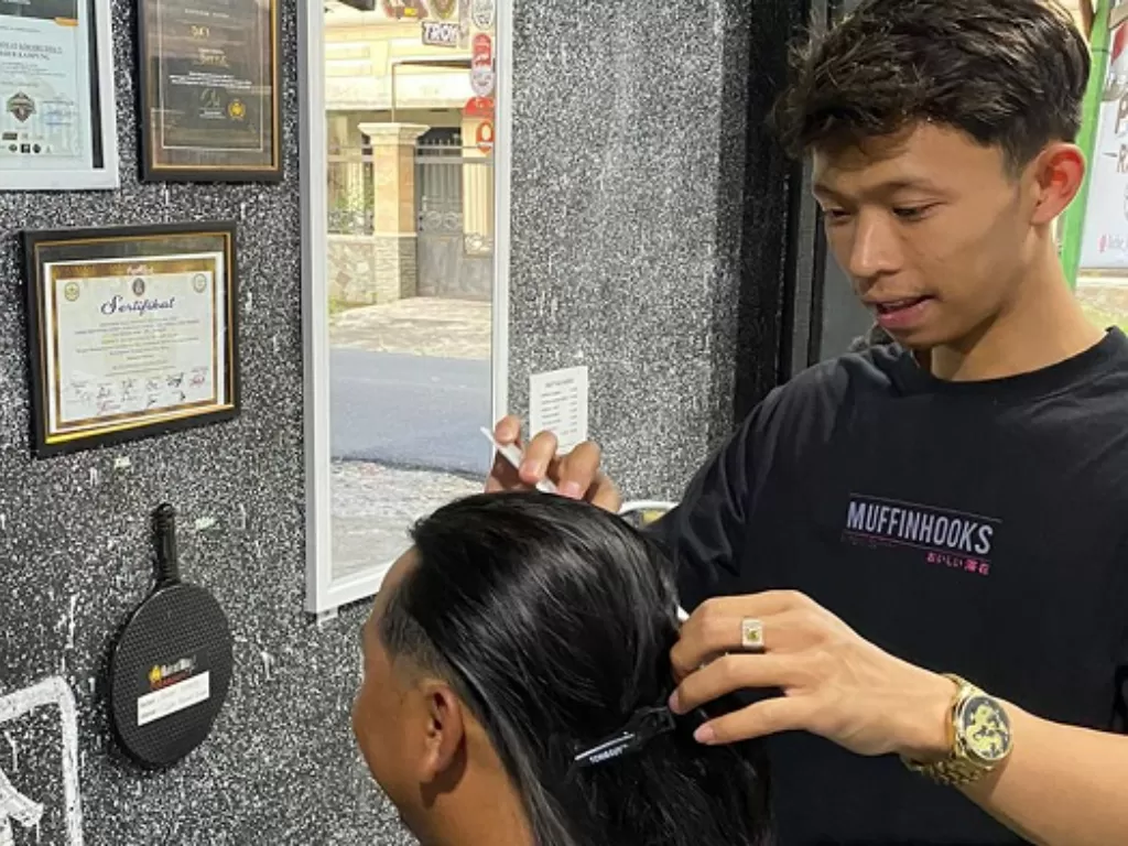 Tukang cukur di Barber Kampung saat mencukur pelanggannya. (Z Creators/Muhammad Thoha Ma'ruf)