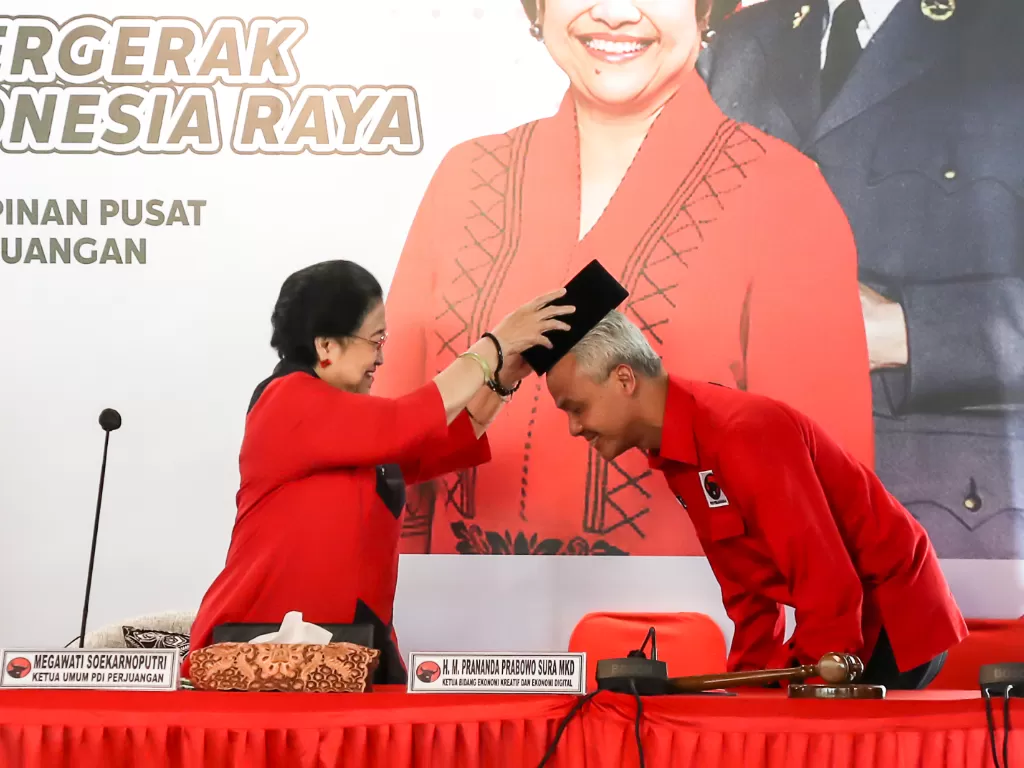 Ketua Umum PDI Perjuangan Megawati Soekarnoputri (tengah) menyematkan peci kepada calon Presiden 2024 yang diajukan PDI Perjuangan Ganjar Pranowo (kanan). (ANTARA FOTO/Monang)