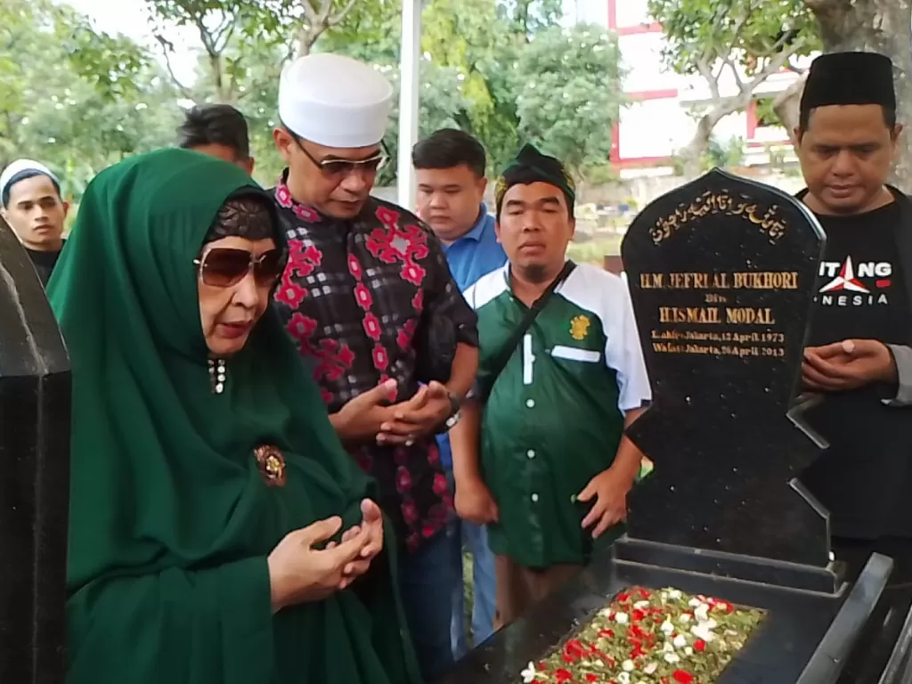 Umi Tatu dan anaknya Ustaz Fajar Sidik ziarah ke makam Uje di TPU Karet Tengsin, Jakarta. (Z Creators/Gunawan)