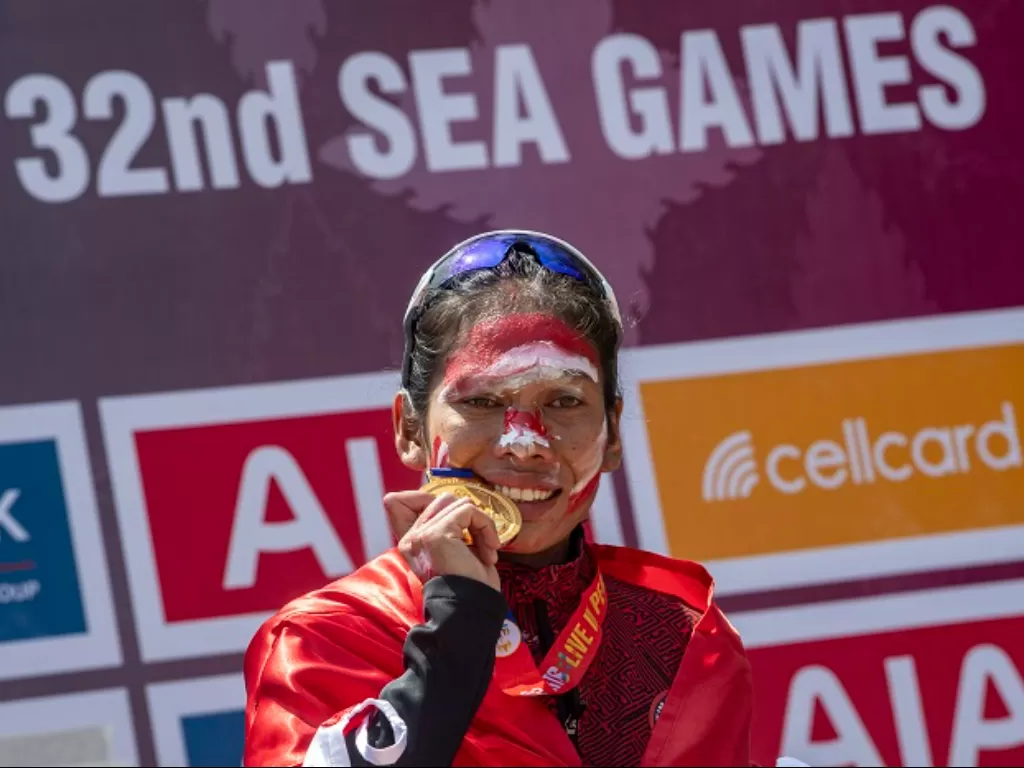 Pelari putri Indonesia Odekta Elvina Naibaho mengigit medali emas saat penyerahan medali marathon SEA Games 2023. (ANTARA FOTO/Muhammad Adimaja)