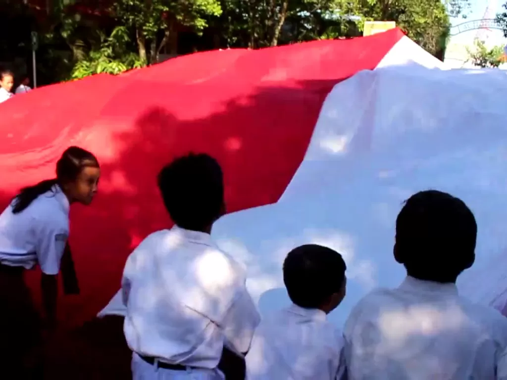Ratusan siswa SD di Solo bentangkan bendera raksasa dukung Timnas Garuda Muda di Sea Games Kamboja. (Z Creators/Purwanto)