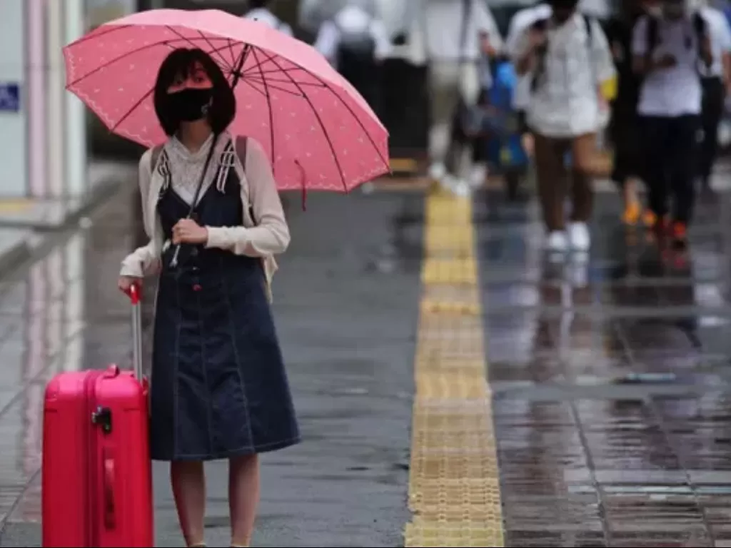 Ilustrasi seorang wanita menggunakan payung saat hujan (ANTARANEWS)
